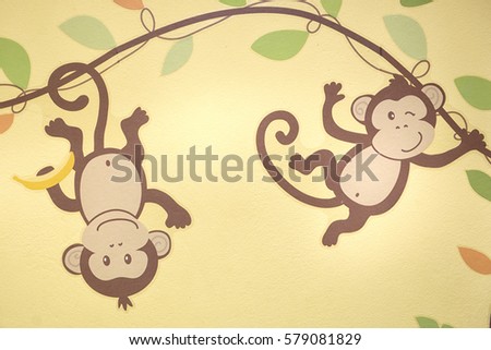 Drawn little monkey on a yellow wall