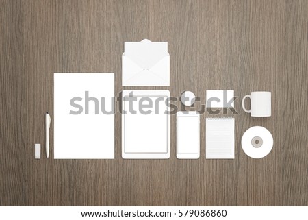 Stationery mockup scene you can use to showcase your branding, identity projects. Paper, tablet, smart phone, pen, envelope, mug, business card, badge pin, cd, pad.
