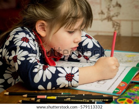 Little girl drawing a picture with color pencils