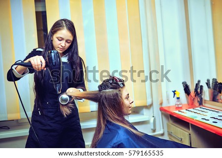 Professional hairdresser drying hair, in studio