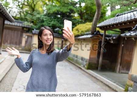 Woman taking selfie photo with mobile phone in kanazawa