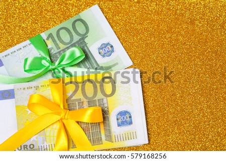 100 and 200  euro bills on golden sparkling background. A lot of money, luxury 