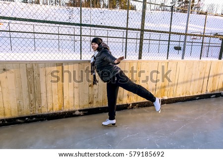 Girl skates at the rink in the winter at sunset
