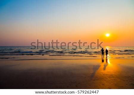 Siluate lovers and beach before sunset background