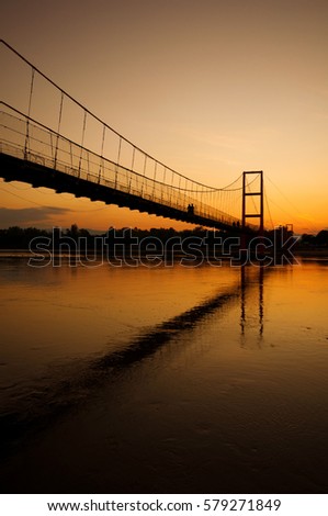 The lover walk along the cable bridge when sunset before the shadow of night come to.