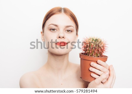 Pretty young woman with cactus in hands