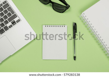 Top view flat lay picture with blank notepad page and different accessories on colored surface