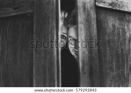 Black and white picture of man and woman hiding in wooden wardrobe