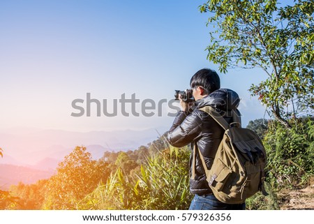 Young professional traveler man with camera shooting outdoor, fa