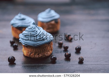 muffin with currants on a dark background next to the berries on the branches. in a rustic style. dark style