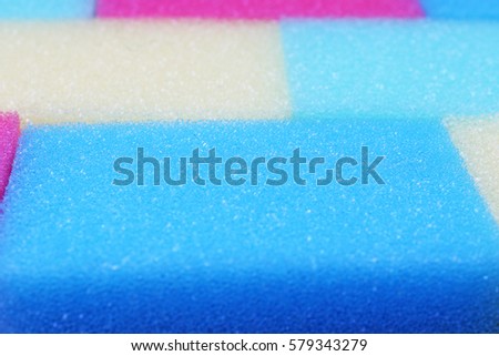 Cleaning kitchen sponge texture as background. Colorful yellow pink green purple blue multicolor sponges. Close up macro about sponges. Sponge pattern textures concept background or wallpaper 
