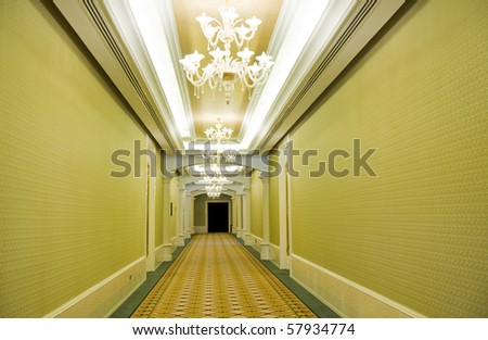 Long hotel corridor with  carpet and green wallpaper