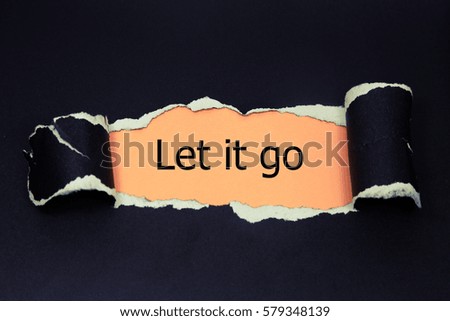 let it go word written appearing behind torn paper.