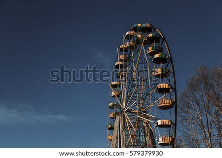 Abandoned ferris wheel against a blue sky