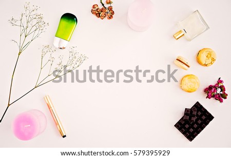 Woman's make up cosmetics, perfumes, natural oil, foundation, macaroons, dark chocolate and pink candles. Beauty blog and social media flat lay on white. Spring mood, copy space