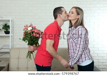 Valentine's day, anniversary, event concept - young woman receives a gift of bouquet of flowers from her boyfriend