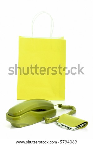 Photo of a telephone and a purse with a shopping bag on the background