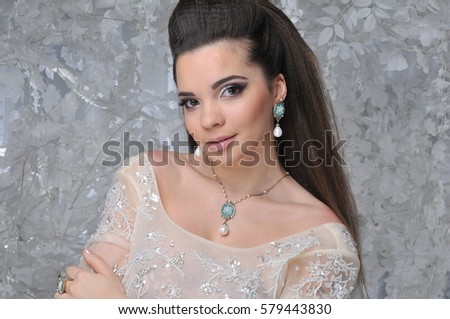 beautiful brunette model girl in long dress with white trees winter background
