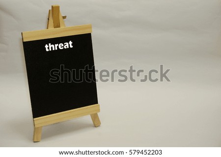 "Threat" written on blackboard isolated over white background. SWOT analysis marketing concept.