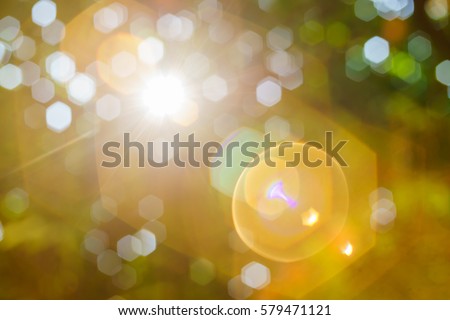 Nature bokeh background and a bright sun light flair. Royalty-Free Stock Photo #579471121
