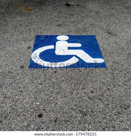 Handicapped sign on the asphalt road in car park