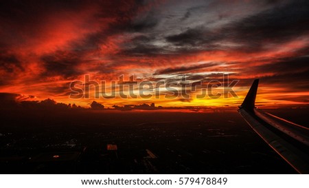 Dramatic red  sunset sky shot from the plane on board.