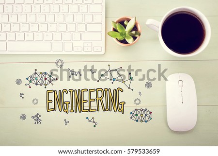 Engineering concept with workstation on a light green wooden desk