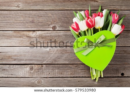 Colorful tulips bouquet and gift box on wooden background. Red and white. Top view with space for your text