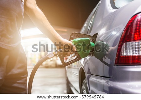 Grey car at gas station being filled with fuel on thailand Royalty-Free Stock Photo #579545764