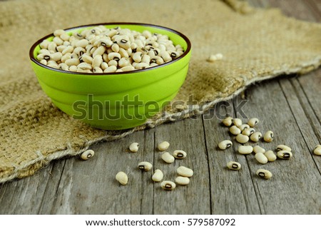 Close up of soy beans in green cup on wooden table background, selective focus and copy space.