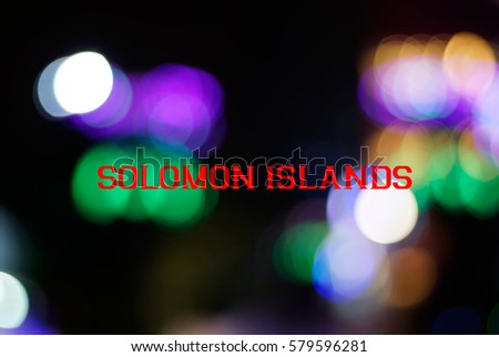 Multicolor light from LED lights close up and bokeh with a wording of SOLOMON ISLANDS. Country name concept for education. Image has grain or blurry or noise when view at full resolution.