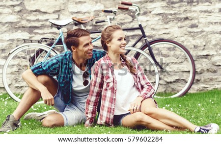Beautiful couple of hipsters having a date in park. Love, relationship, romance concept.