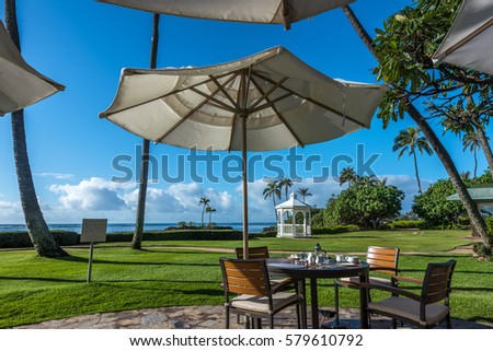 early morning breakfast table under umbrella off of Hawaii beach