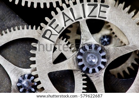 Macro photo of tooth wheel mechanism with REALIZE concept letters