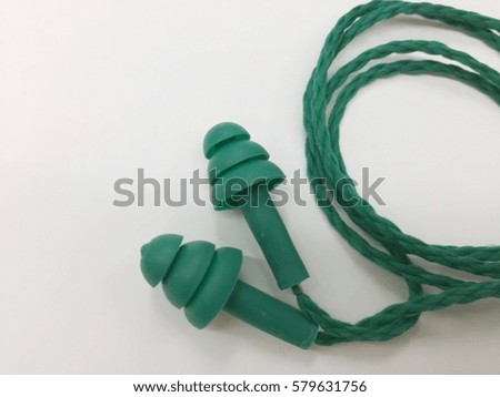 Green earplugs on white background with copy space in healthcare concept