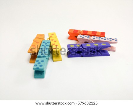 Colorful paper clips with similar shape to laundry clip made of wood isolated on white background