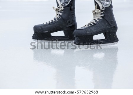 Man skating with black skates on the ice area at the seashore in winter day. Weekends activities outdoor in cold weather. 