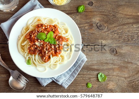 Spaghetti bolognese pasta with tomato sauce and minced meat, grated parmesan cheese and fresh basil - homemade healthy italian pasta on rustic wooden background Royalty-Free Stock Photo #579648787