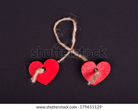 Two red hearts together bound with rope, concept of love and marriage. Isolated on white background