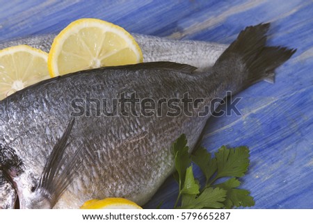 bream with parsley and lemon on bottom of wood blue