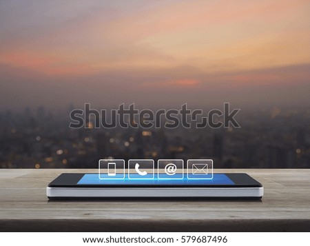 Telephone, mobile phone, at and email buttons on modern smart phone screen on wooden table over blur of cityscape on warm light sundown, Customer support concept