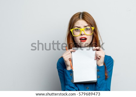 A young woman with a clean white sheet of paper for text looks into camera