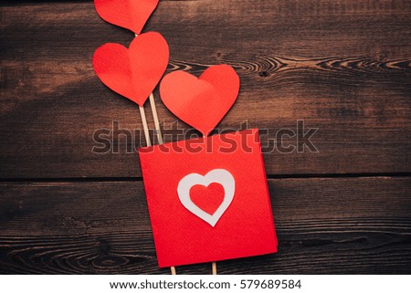 Hearts and postcard on wooden background