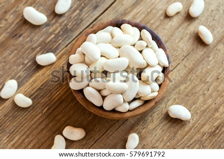 Organic Raw White Beans in wooden bowl close up - healthy ingredient for diet vegan vegetarian protein food meal cuisine, ready for cooking