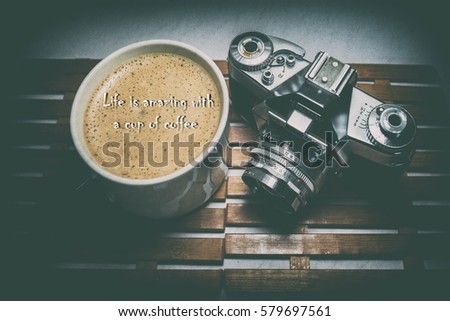 Overhead view a cup off coffee a film camera and a qoutes about coffee(Life is amazing with a cup of coffee)