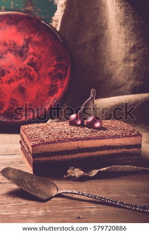 Homemade cherry cake with chocolate decor on a rustic style background. Selective focus. Toned.