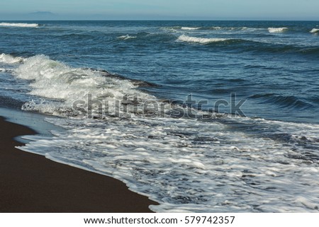 Khalaktyrsky beach with black sand. Pacific Ocean washes the Kamchatka Peninsula.
