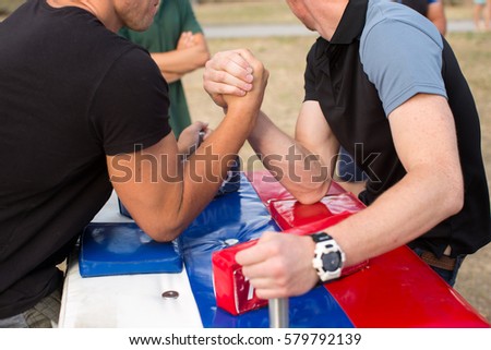 people, leisure, challenge, competition and competition concept - close up of male friends in arm wrestling match
