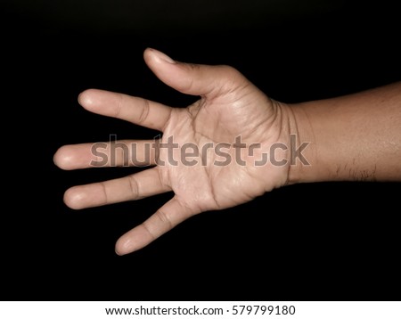Male hand is showing five fingers on black background