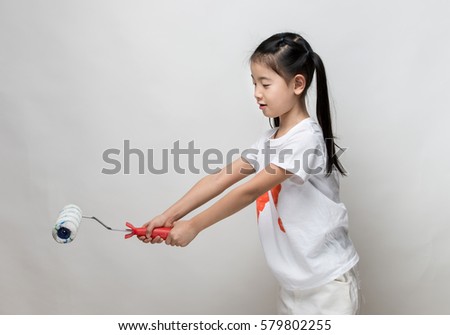 Cute asian girl holding paint roller